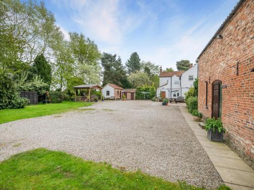 an empty driveway in front of a brick building at The Hayloft - 17238 in York