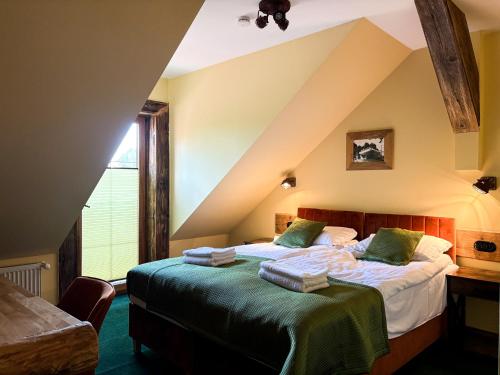 a bedroom with two beds in a attic at Dymer in Biskupiec