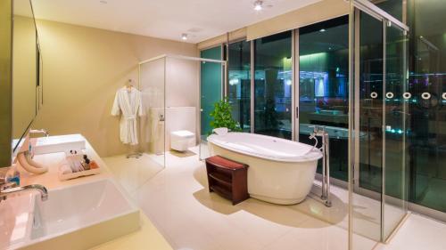 a bathroom with a tub and a toilet and a sink at ONE15 Marina Sentosa Cove Singapore in Singapore