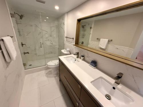 a bathroom with a sink and a shower and a toilet at Sunset Beach 101 Beach Front Unit in Holmes Beach