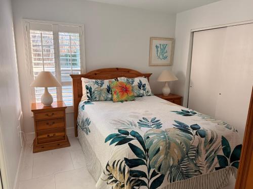 a bedroom with a bed and two lamps and a window at Sunset Beach 101 Beach Front Unit in Holmes Beach