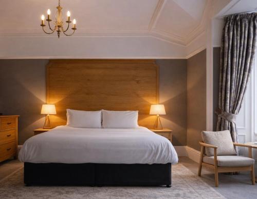 a bedroom with a large bed and a chandelier at Lyzzick in Keswick