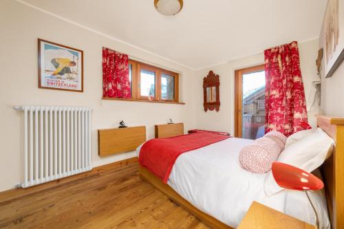 a bedroom with a bed with red curtains and a window at Maison Carrel Elegant 4 in Breuil-Cervinia