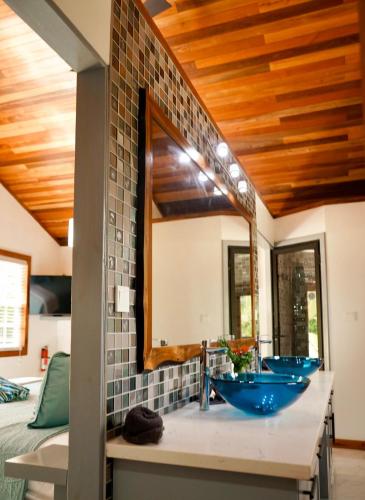 a bathroom with two blue sinks and a mirror at Mangata Villas Adults Only in San Pedro