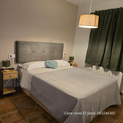 a bedroom with a bed with a headboard and two lamps at Casa Rural El Jaral in Orihuela del Tremedal