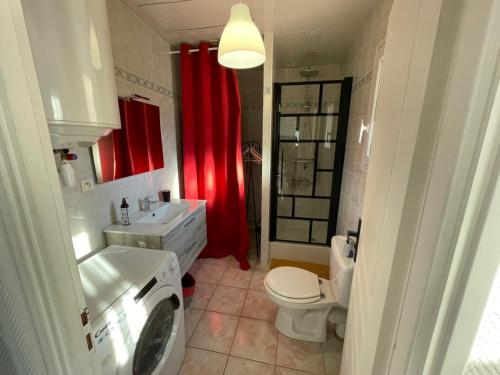 a bathroom with a toilet sink and a washing machine at L'Opaline-Maisonnette 28m2 grand confort avec jardin-tout inclus in Tully