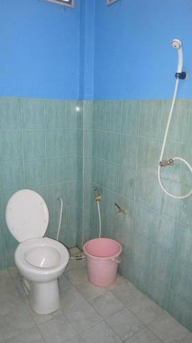 a bathroom with a toilet and a pink bucket at Bang Nam Kem Resort in Ban Tai