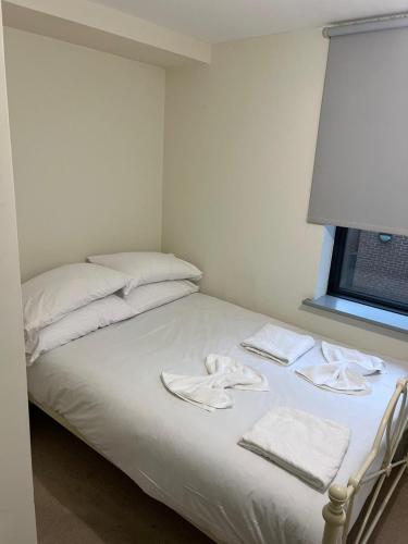 a bed with white sheets and towels on it at 4 Private Rooms in Shared Apartment with Kitchen in Leeds