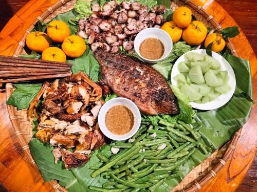 a plate of food with meat and vegetables on a table at Diễn homestay in Quang Ba