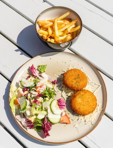 ein Teller mit Essen, Salat und Pommes frites in der Unterkunft ibis De Haan in De Haan
