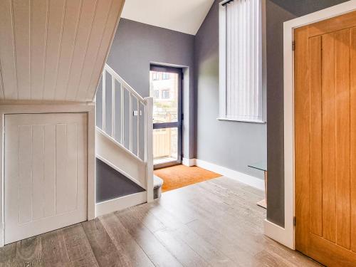 a hallway with a staircase and a door and a stair case at The Stables - Uk38514 in Babcary