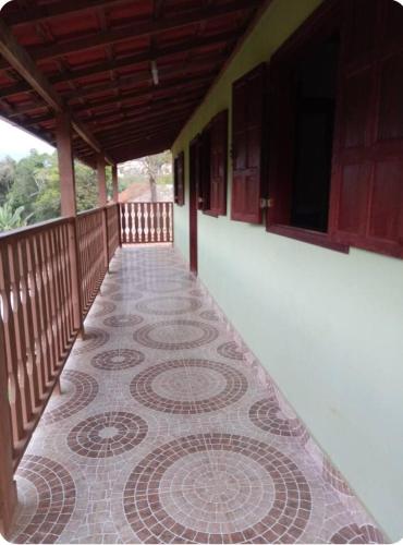a balcony with a tiled floor on a building at Cantinho da Nara em Ibitipoca in Conceição da Ibitipoca