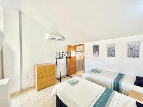 a room with two beds and a dresser at Amapolas by Villas&You in Orihuela Costa