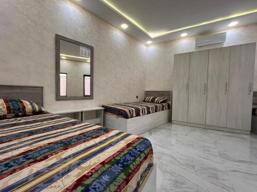 a bedroom with two beds and a mirror at Ganja VIP Home in Ganja