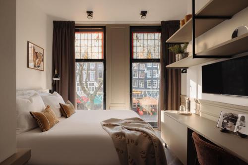 a bedroom with a large bed and a large window at Adam Downtown in Amsterdam