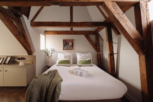 a bedroom with a large white bed with wooden beams at Adam Downtown in Amsterdam