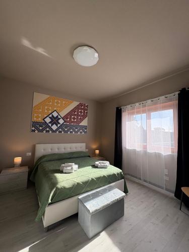 a bedroom with a bed and a painting on the wall at Dimora Alta in Olbia