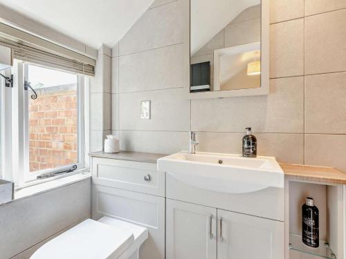 a white bathroom with a sink and a toilet at 1 Bed in Broadway oc-broad in Broadway