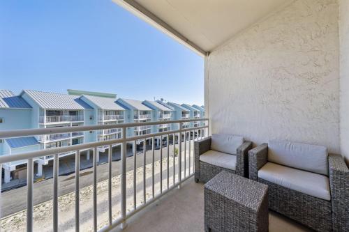 a balcony with two chairs and a view of a building at Sugar Beach 313 in Gulf Shores