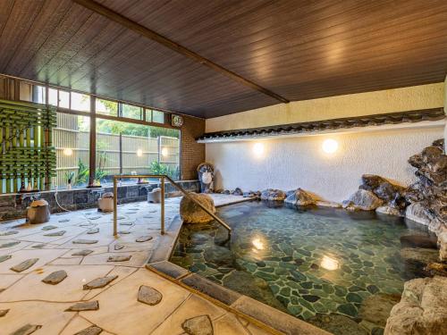 a pool of water in a room with a waterfall at かね吉一燈庵 in Mitaka