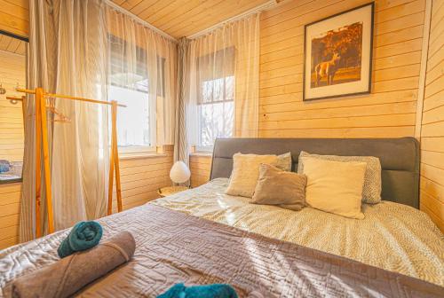 a bedroom with a bed in a room with wooden walls at Lazy Deer - Camp in Staniszów