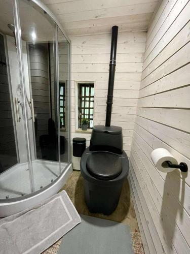 a bathroom with a black toilet and a shower at Peaceful Forest Cabin in Nature in Paluküla
