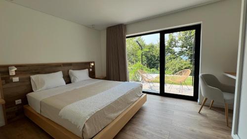 a bedroom with a bed and a sliding glass door at Chestnut hill - Geres in Ventosa