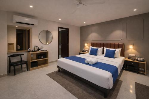 a bedroom with a large bed with blue pillows at Qotel Comfort Golden Saffron - Hotel in Punjabi Bagh Near Metro in New Delhi