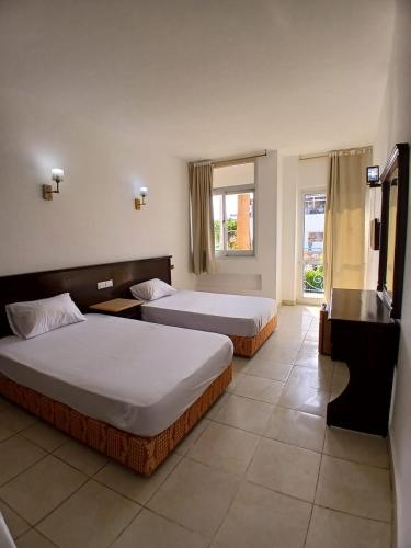 a bedroom with two beds and a window at Regency Hotel Sharm in Sharm El Sheikh