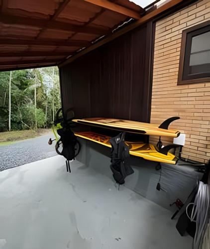 a table with a surfboard on top of a building at Beautiful View Villa: Sea and Forest in São Francisco do Sul
