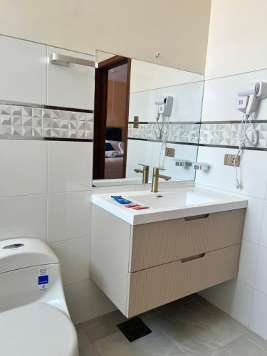 un bagno con lavandino, WC e specchio di Hostal Alvasar a Copacabana