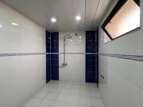 Un baño con ducha con azulejos azules y blancos. en Ganja Apartment, en Ganja