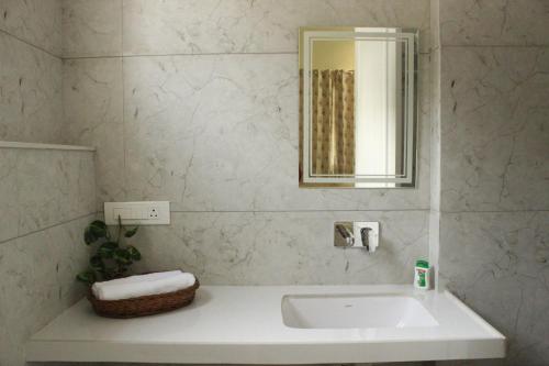 a white bathroom with a sink and a mirror at Ratan Vilas in Jaipur