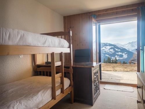a room with bunk beds and a window with a view at Comfortable 2 bedroom apartment in Gryon in Gryon