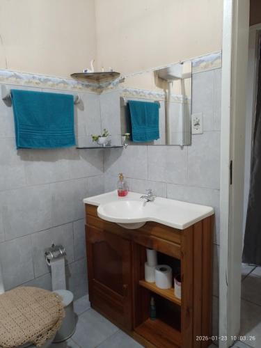 a bathroom with a sink and a mirror and a toilet at Casa de Alquiler Cláudia in Pântano Grande