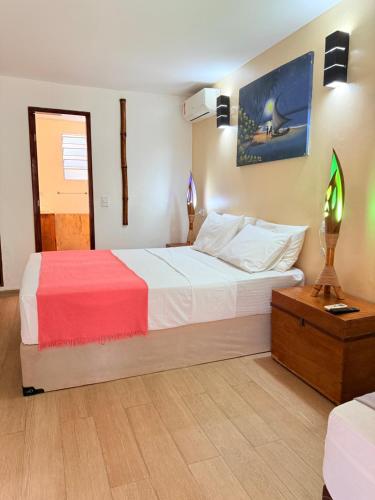 a bedroom with a large bed with a red and white blanket at Rede Andrade Calamarina in Jericoacoara