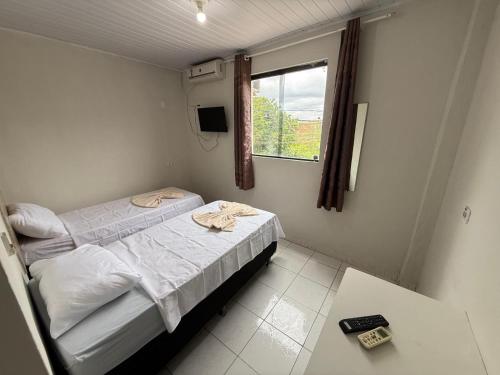 a small bedroom with a bed and a window at Hotel Solaris in Senhor do Bonfim