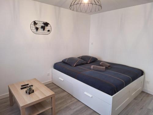 a bedroom with a large bed and a table at Faubourg des voyageurs 4 - Studio climatisé 2 personnes - proche axe autoroute in Saran