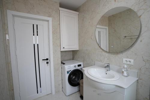 a bathroom with a sink and a toilet and a mirror at Apartament Ultracentral NICOL in Curtea de Argeş