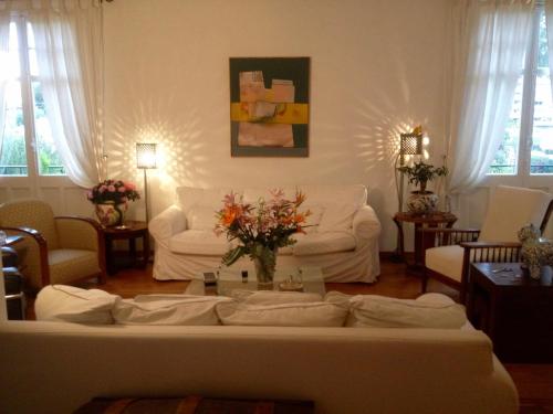 un salon avec un canapé et une table avec des fleurs dans l'établissement Villa Prétorina, à Cannes