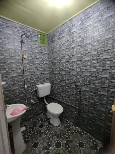 a bathroom with a shower and a toilet and a sink at Mokdo Guest House in Perhentian Islands