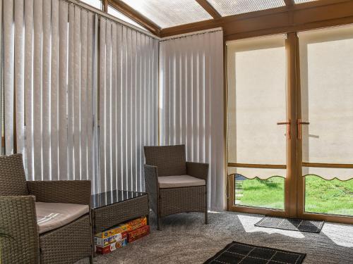 a waiting room with two chairs and a window at Zebra House in Blaenavon