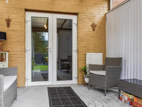 an open door to a patio with chairs and a table at Zebra House in Blaenavon