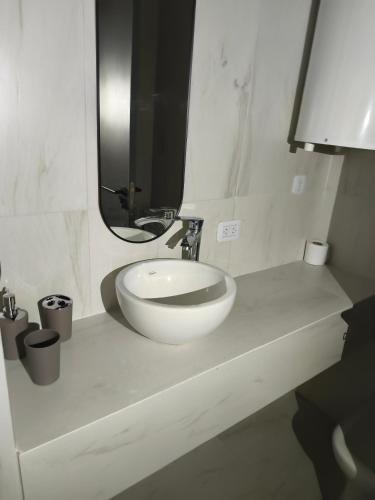 a bathroom with a white sink and a mirror at San Pedro, Cristal INN in San Pedro