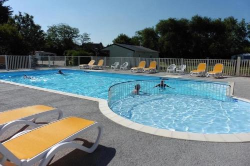 a large swimming pool with chairs and people in it at ZEcamping 3 étoiles animaux acceptés avec piscine chauffée à Guérande in Guérande