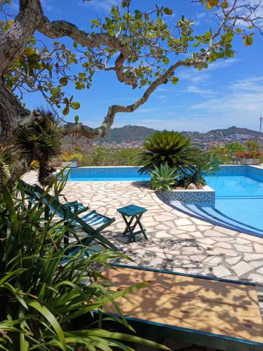 a swimming pool with a picnic table and a tree at Casa Dos Arcos Bed and Breakfast in Arraial do Cabo