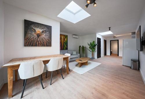 a living room with a table and chairs and a painting at The Vault - Eindhoven - By T&S in Eindhoven