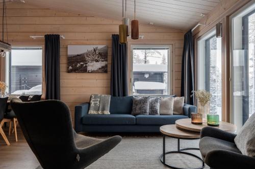 a living room with a blue couch and a table at Louhi B in Äkäslompolo