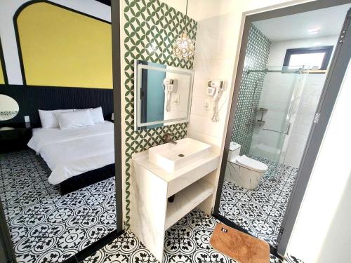 a bathroom with a bed and a sink and a mirror at Villa RonRoy Hà Tiên in Hà Tiên