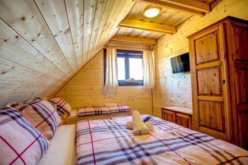 a bedroom with two beds in a log cabin at Drevenica pod Sitieňom 2 in Svätý Kríž